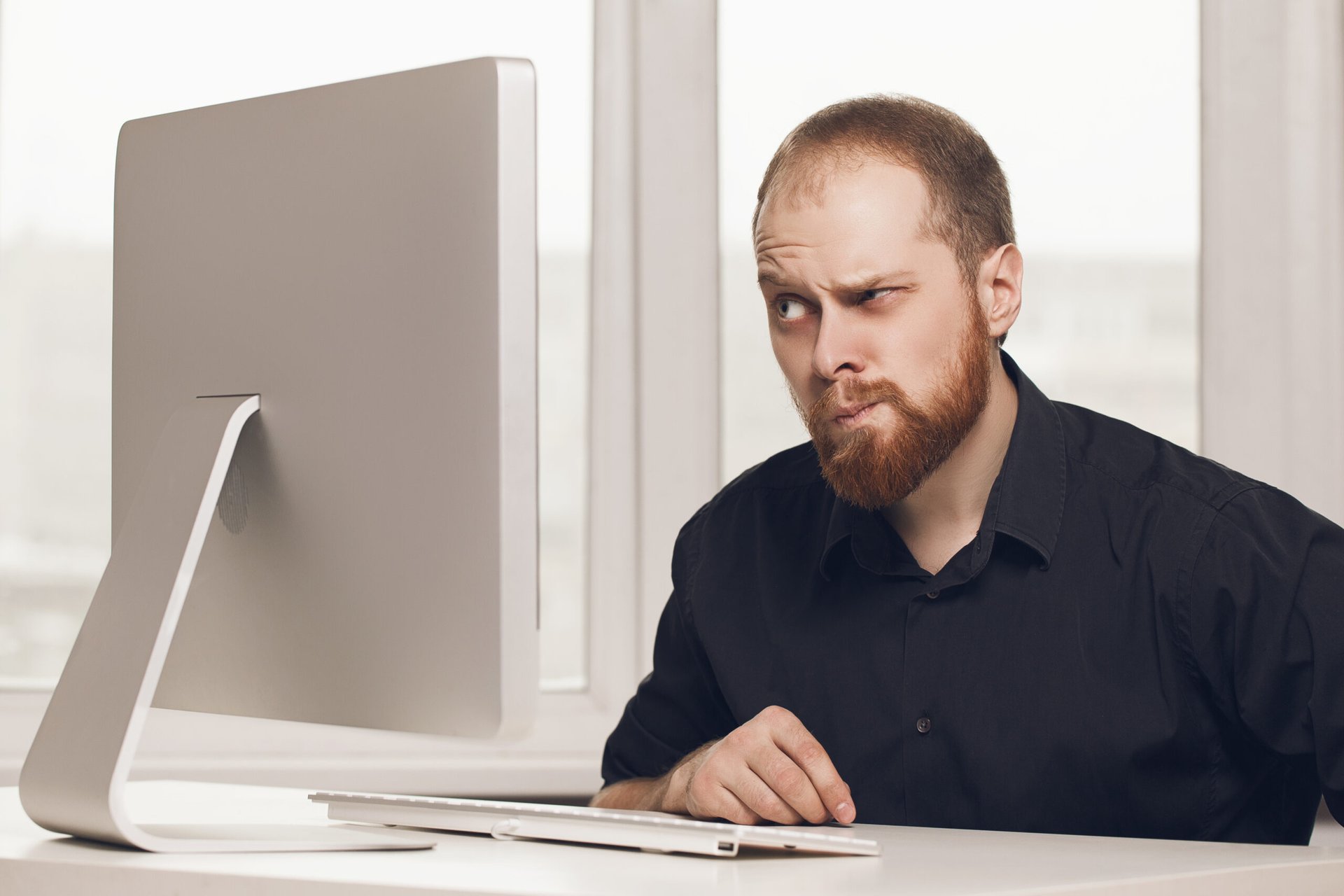 Suspicious man looking at a computer screen