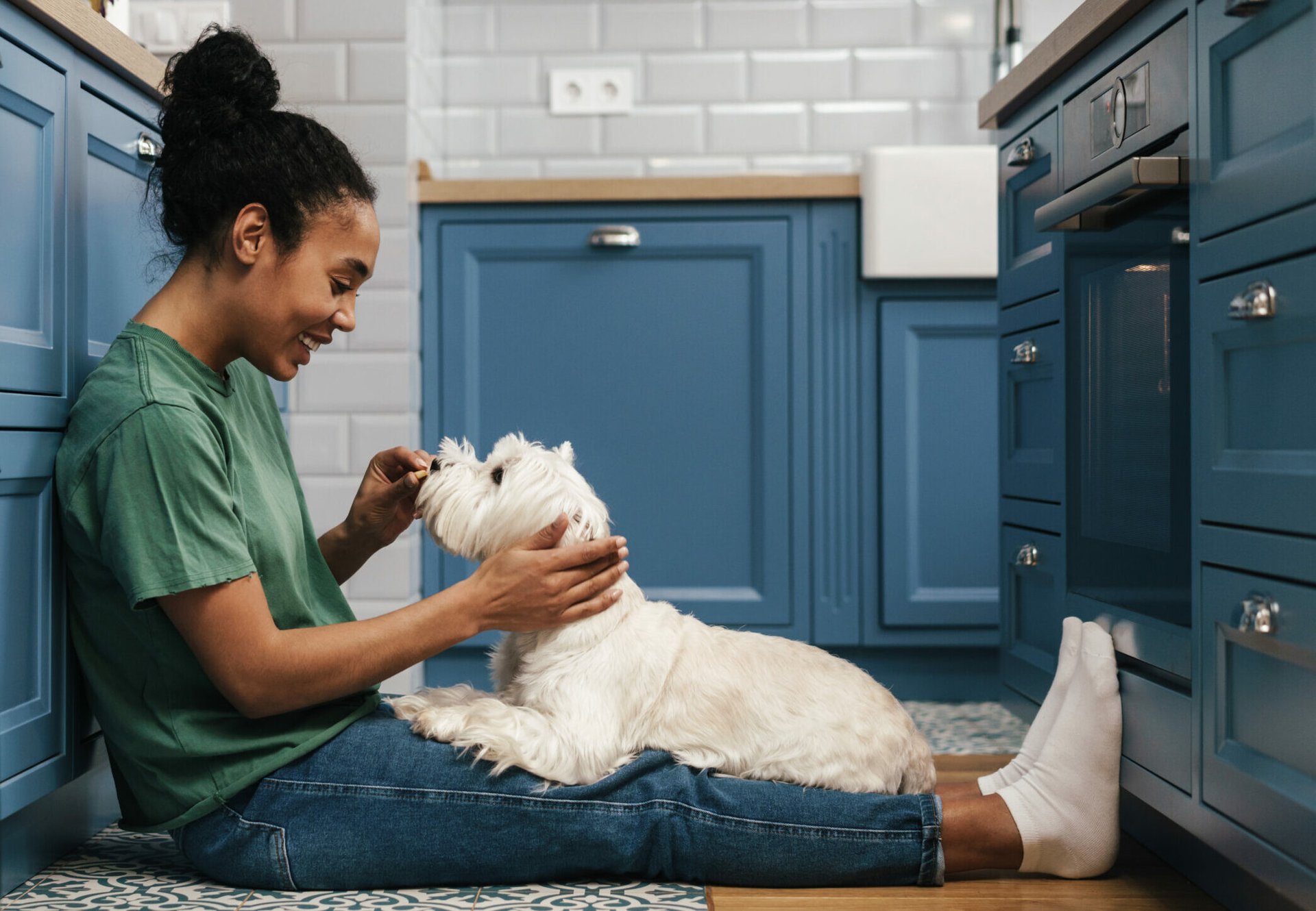Woman feeding her dog in her kitchen