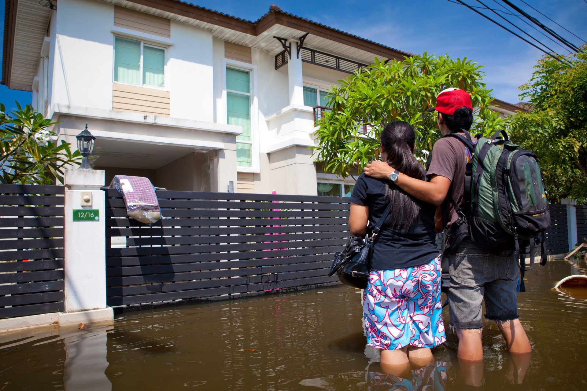 Couple outside their flooded house