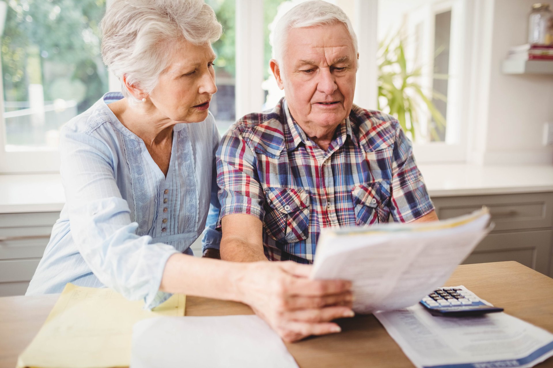 Senior couple looking at bills at home