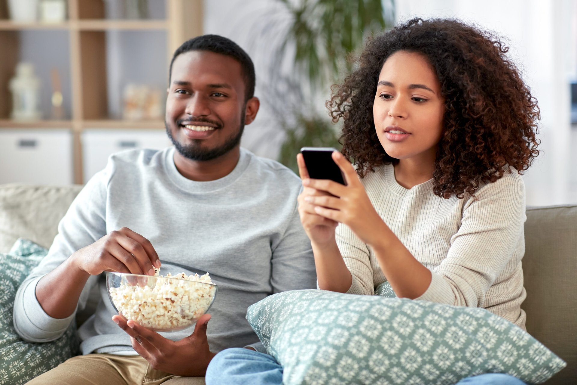 Couple watching TV or streaming while on phone