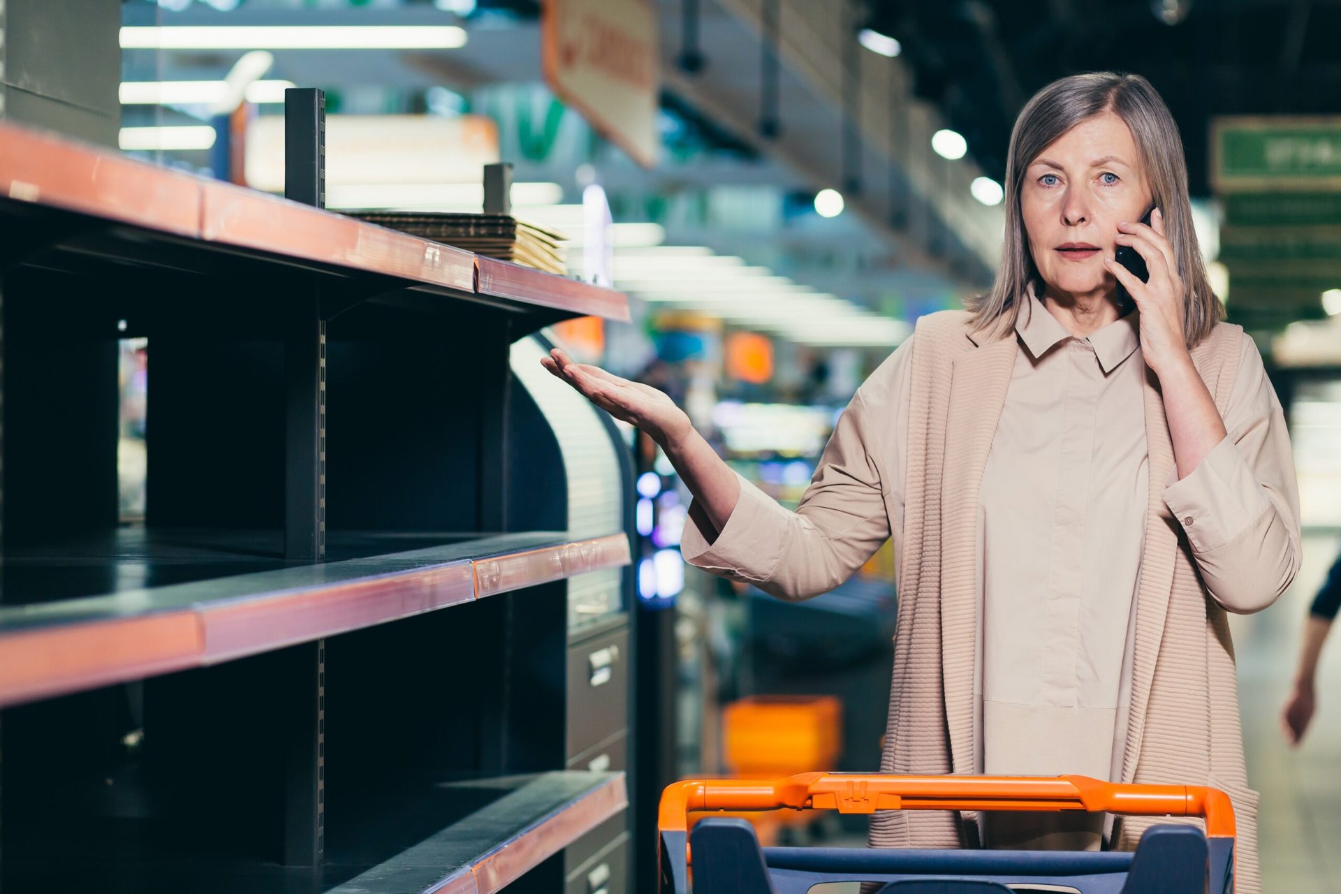 Woman next to an empty grocery store shelf