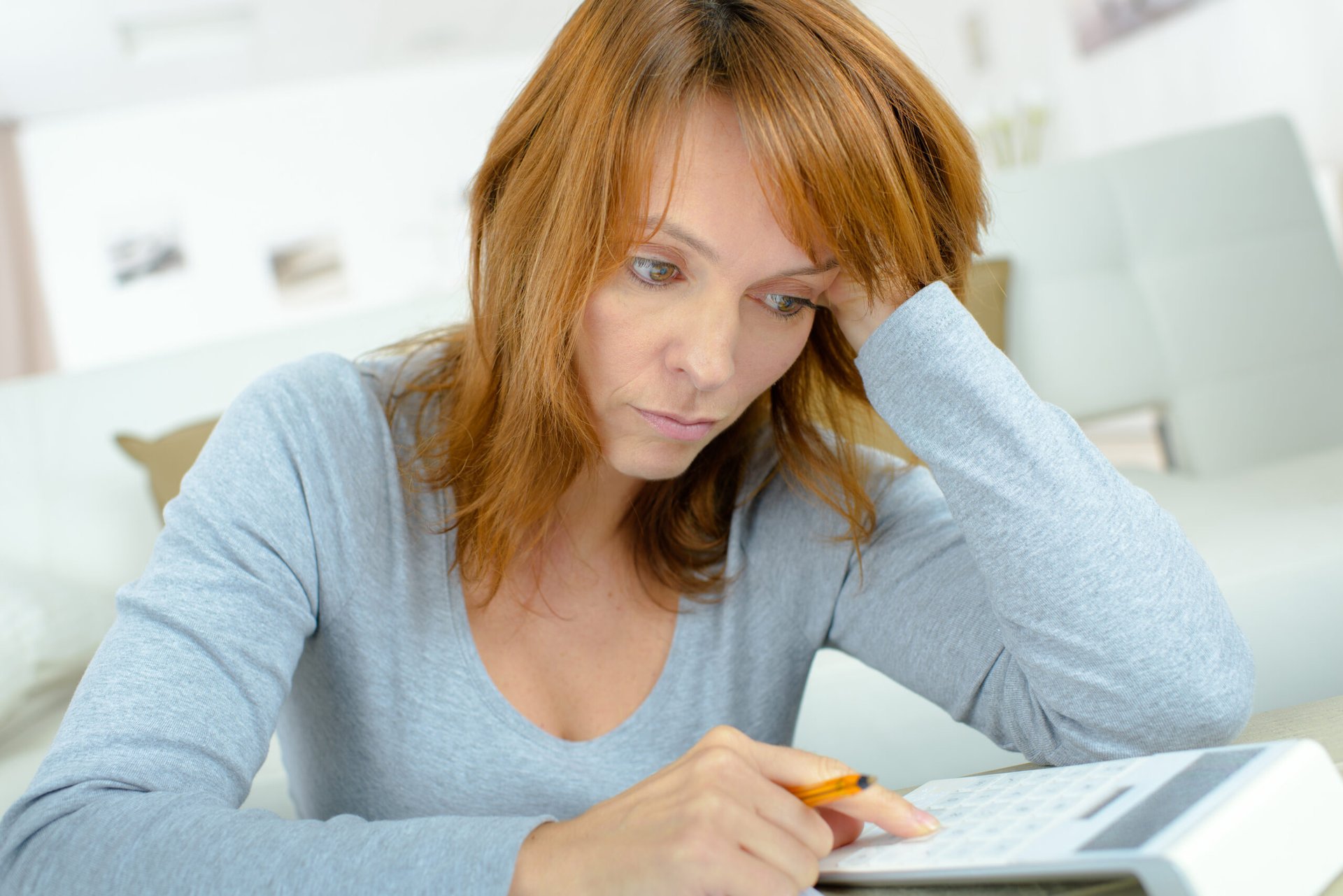Stressed woman calculating income or expenses