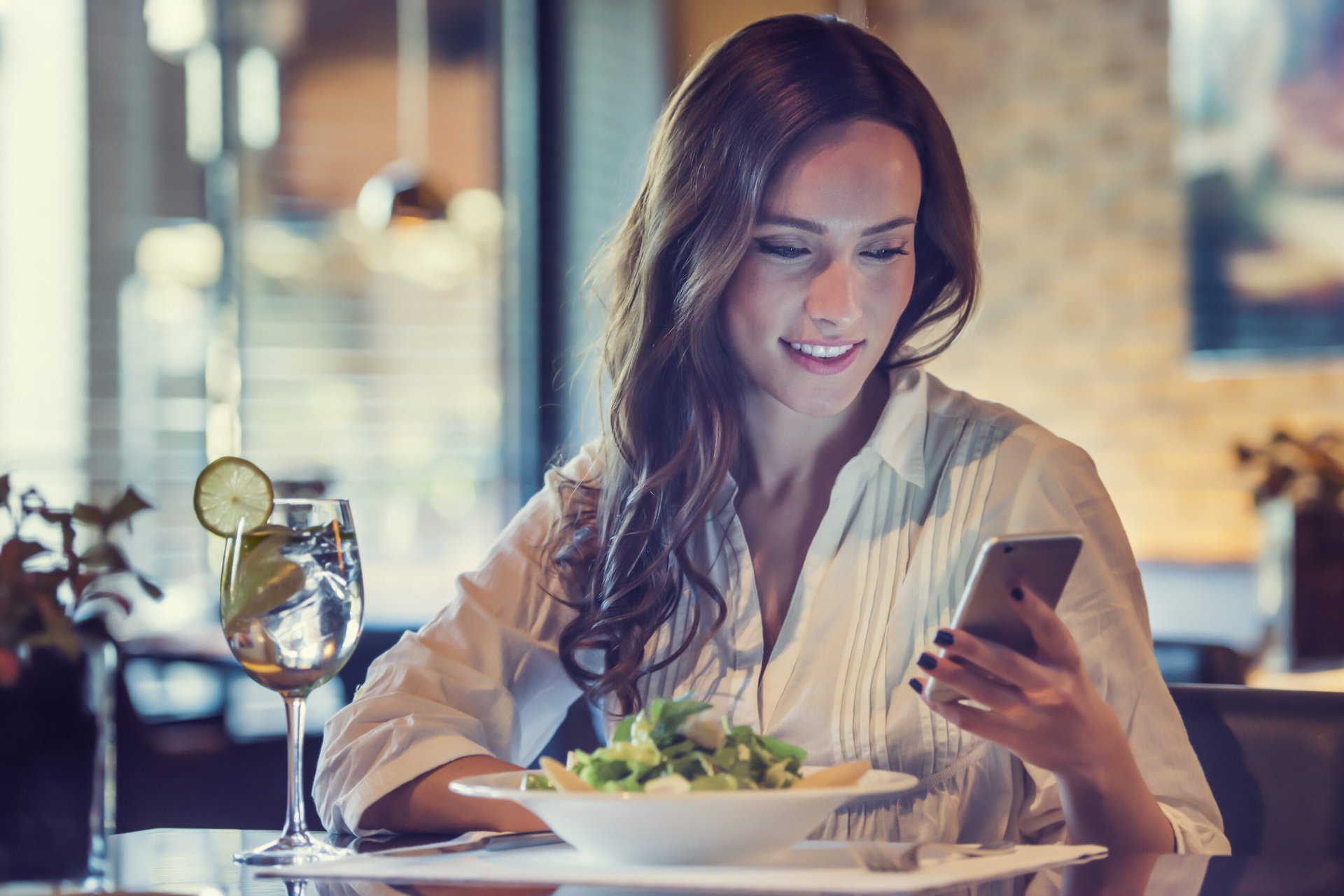 Young woman in a restaurant looking at her phone
