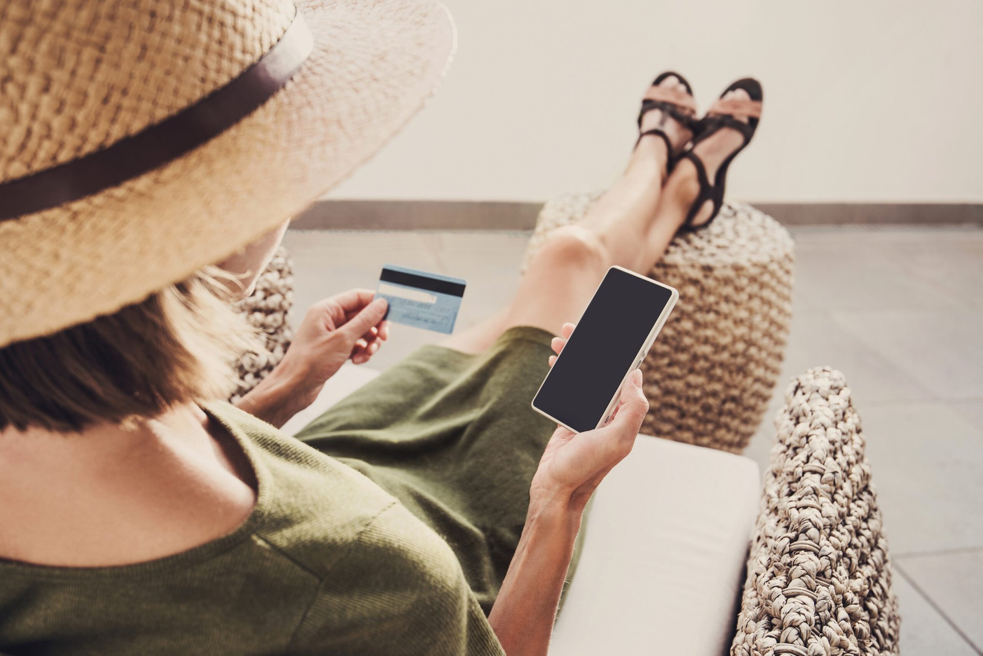 Woman on vacation looking at credit card and phone