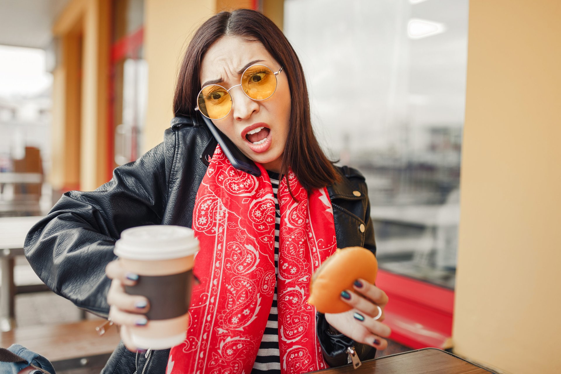 Unhappy woman holding a coffee and bagel