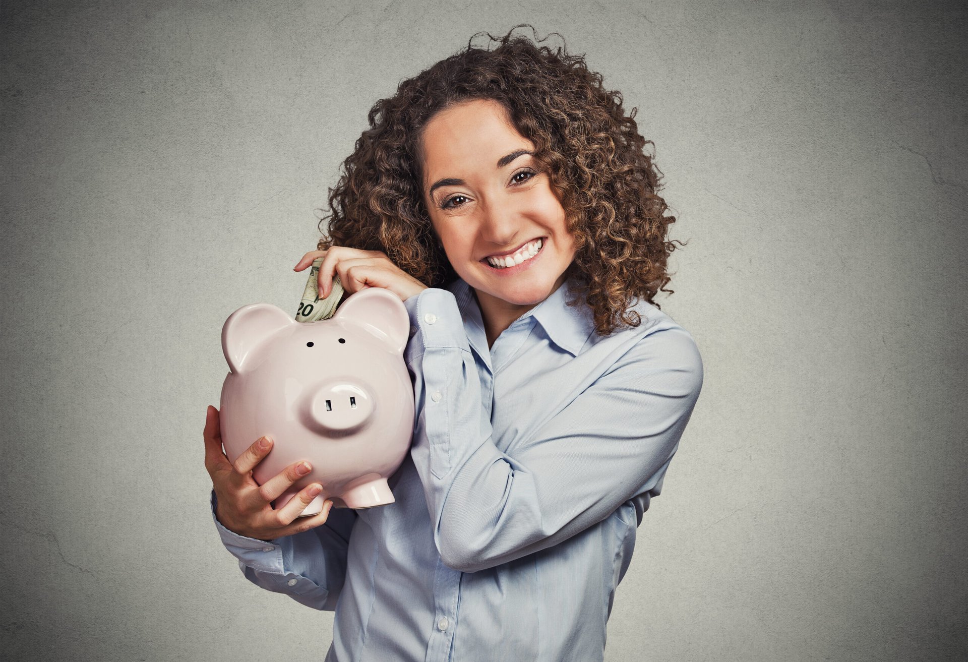Woman putting money into piggy bank