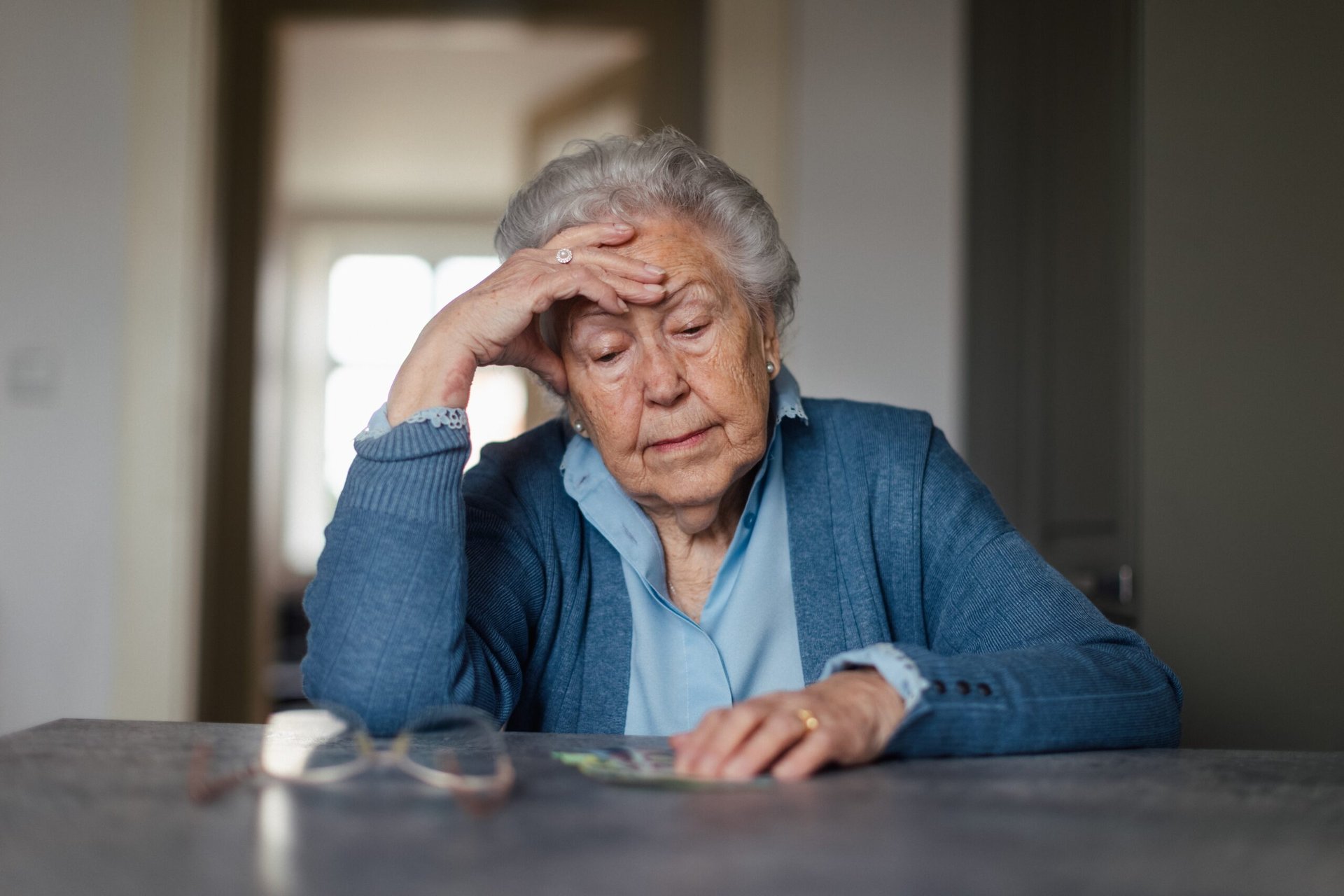 Unhappy senior woman counting her money