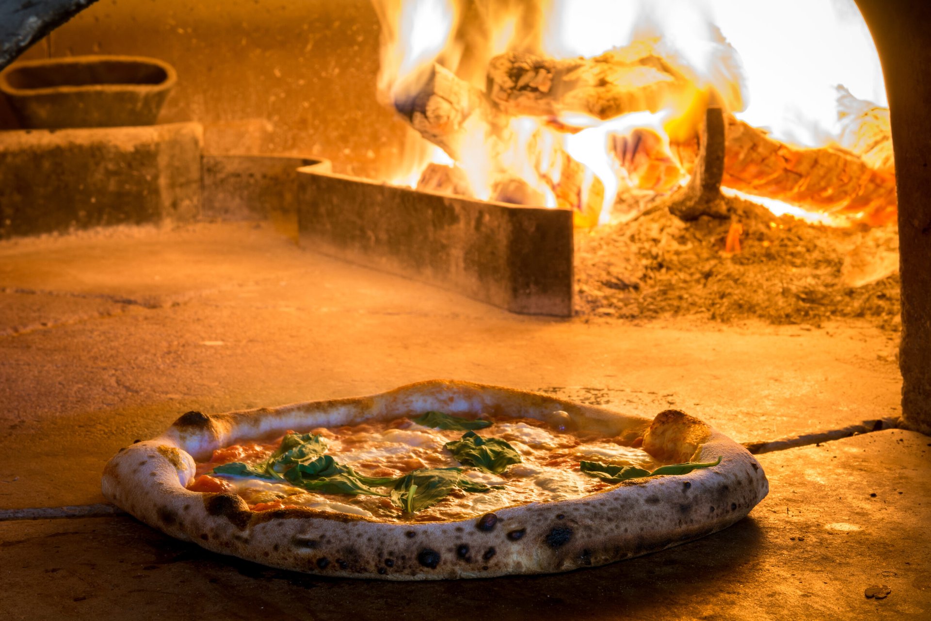 Pizza baked in front of a wood fire oven