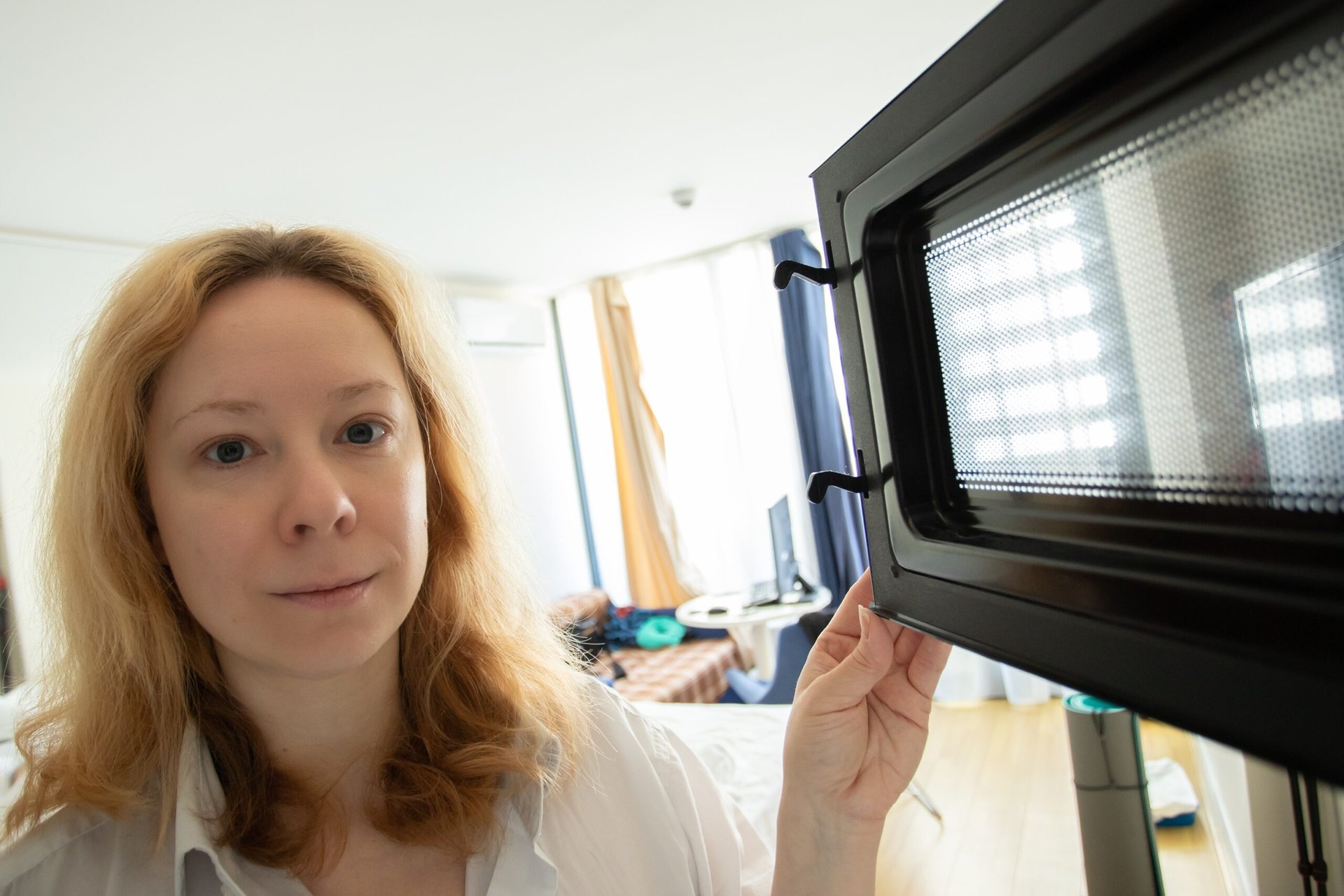 Woman opening a microwave door