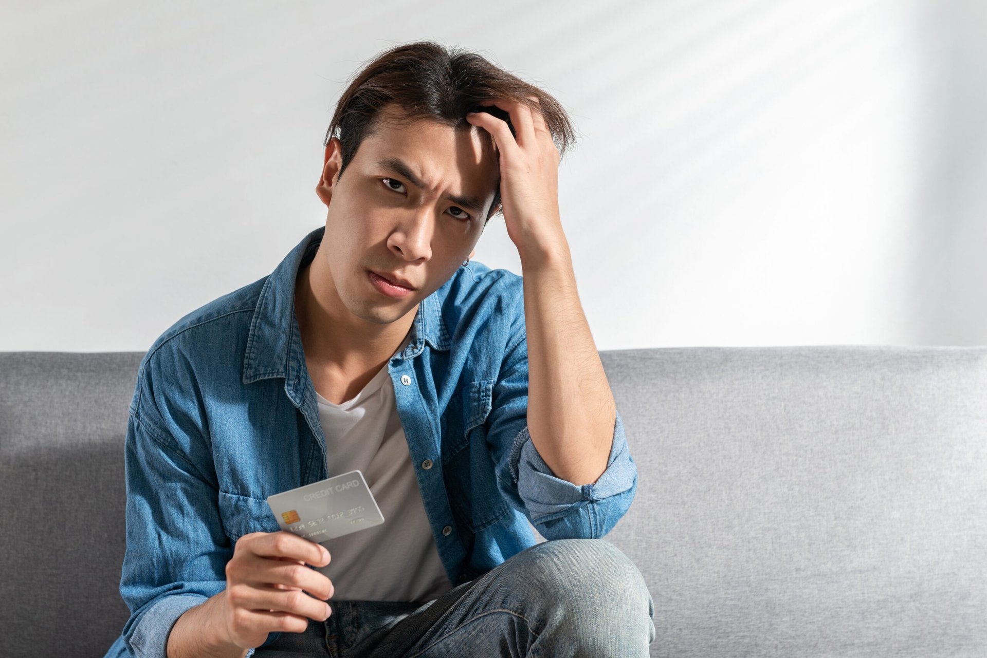 Unhappy man holding a credit card