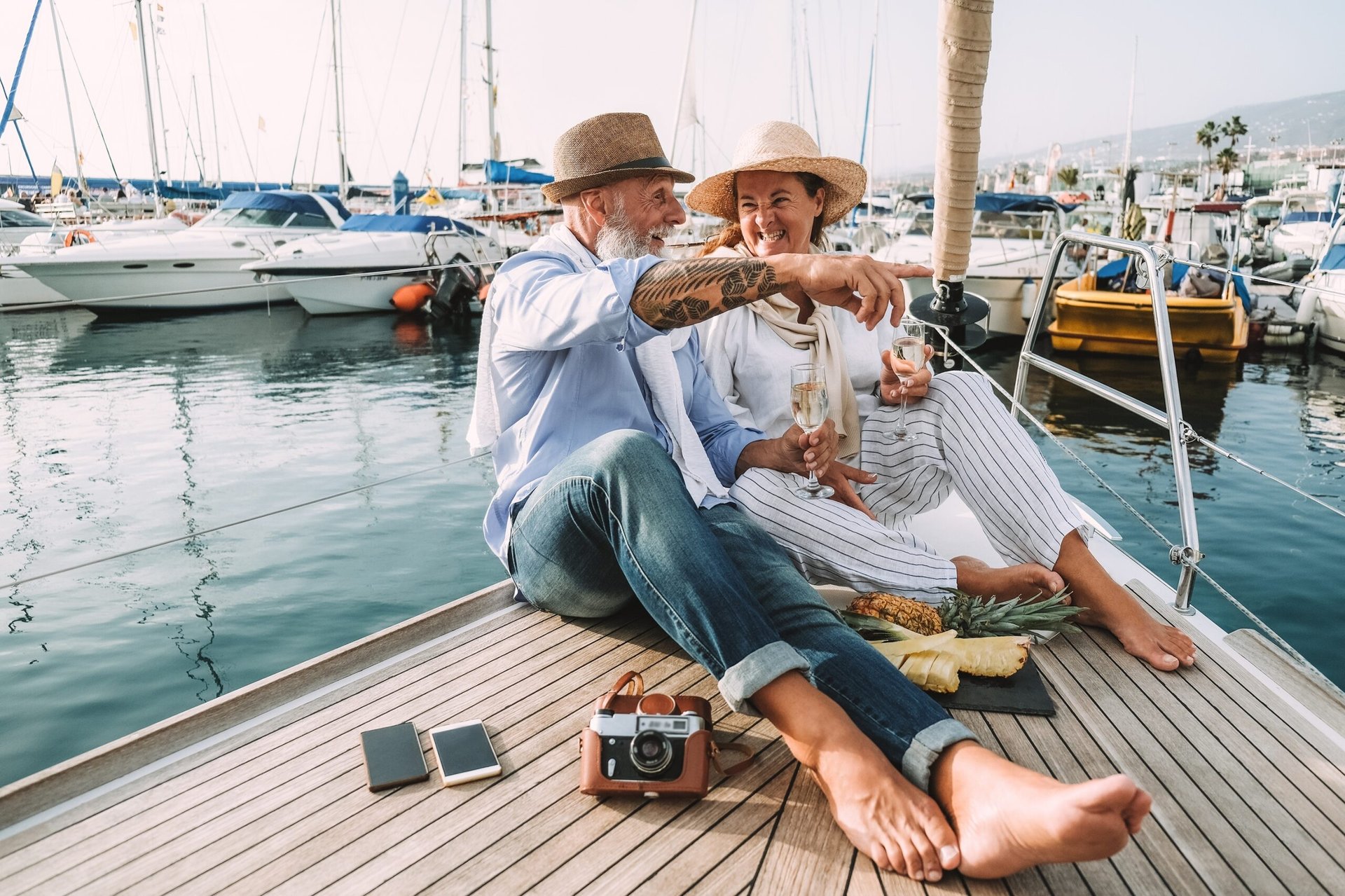 Retired couple drinking champagne on sailboat