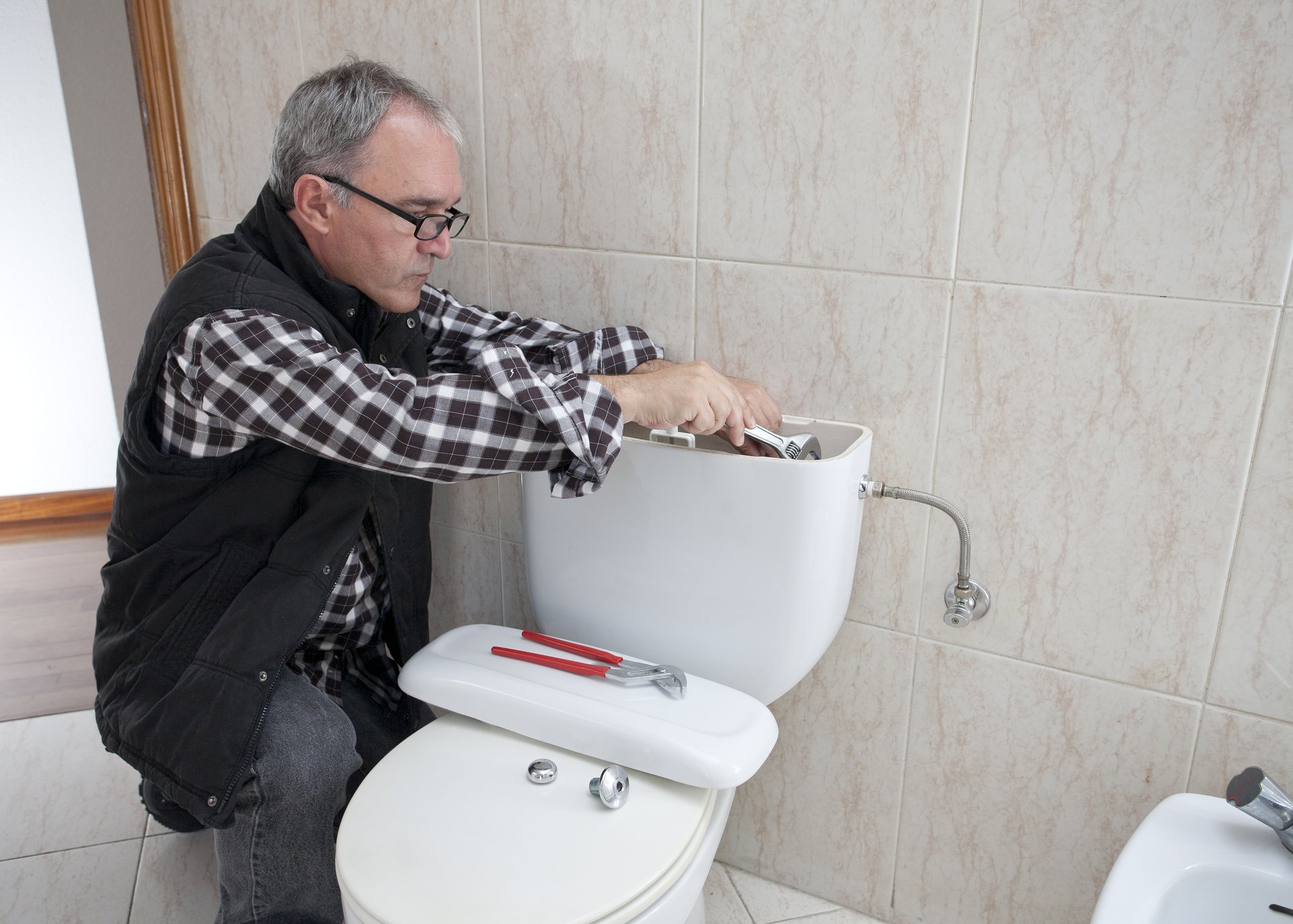 Plumber repairing a toilet