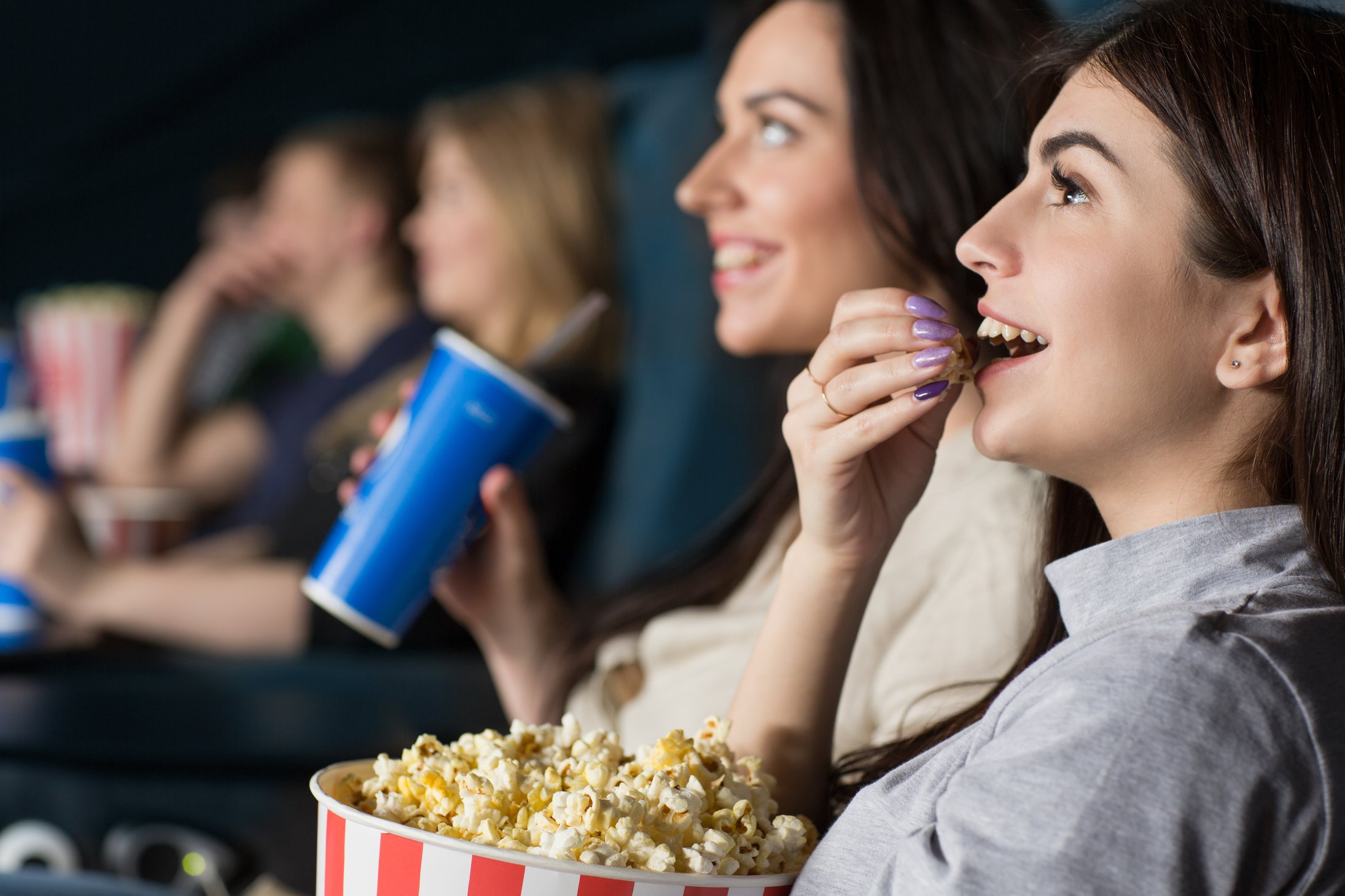 Friends watch a movie. Подруги в кинотеатре. Подруги едят попкорн. Девушки подруги с попкорном. Девушка с попкорном в кинотеатре.