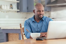 Man using a laptop in his kitchen