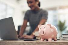 Woman working with a piggy bank on her desk