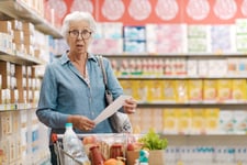 Shocked senior woman looks at grocery bill