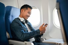Man looking at his phone on airplane.