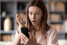 Shocked woman looking at her phone