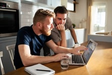 Couple looking at a laptop at their kitchen table