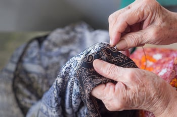 Elderly woman hand sewing