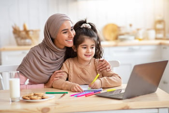 Mom Helping Her Daughter To Study With Laptop At Home