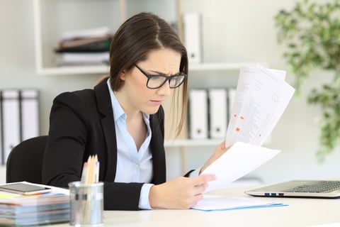 Worried accountant or businesswoman working in an office confused or stressed by financial numbers while working on a laptop