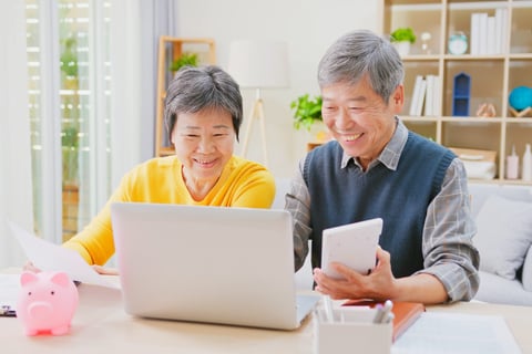 Happy senior couple saving money and budgeting or doing math for retirement income