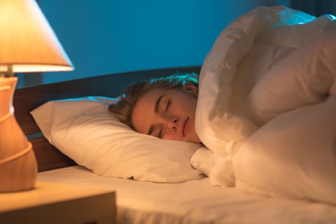 A woman sleeping with the light/lamp on.