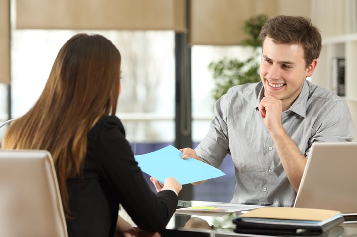 Man across desk from woman.