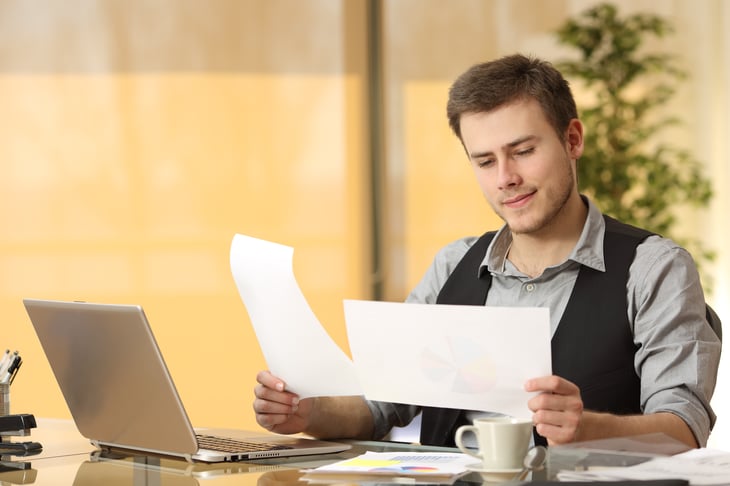 Guy looking at two papers