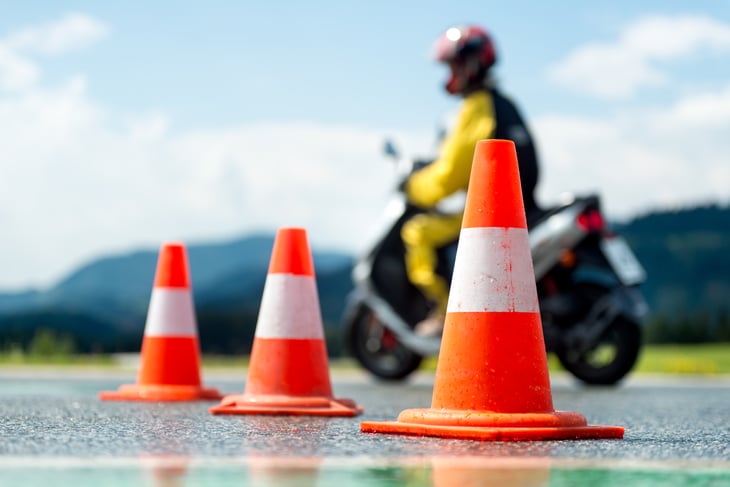 Motorcycle driving among traffic cones.