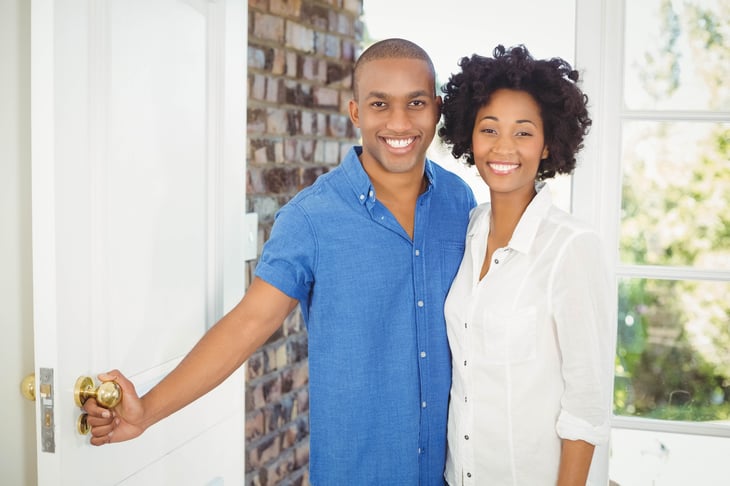 African American couple opening door to their home.