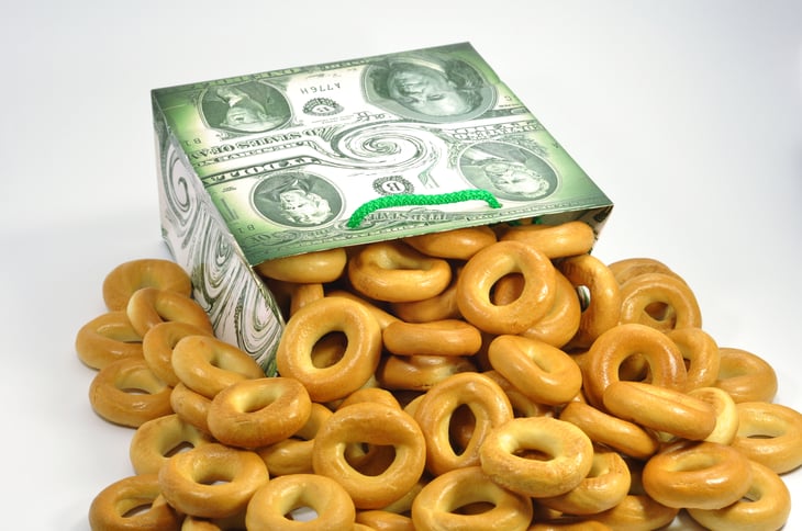 Bagels pouring out of a box made of US currency
