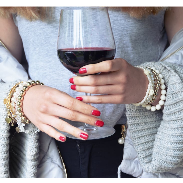 Woman's hands holding a glass of wine.