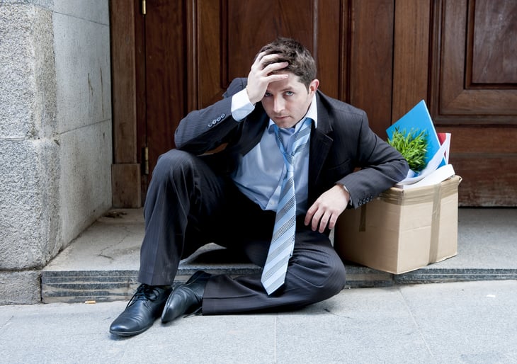 Distressed employee with office belongings after losing job