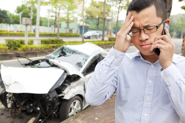 A man makes a phone call after a car crash