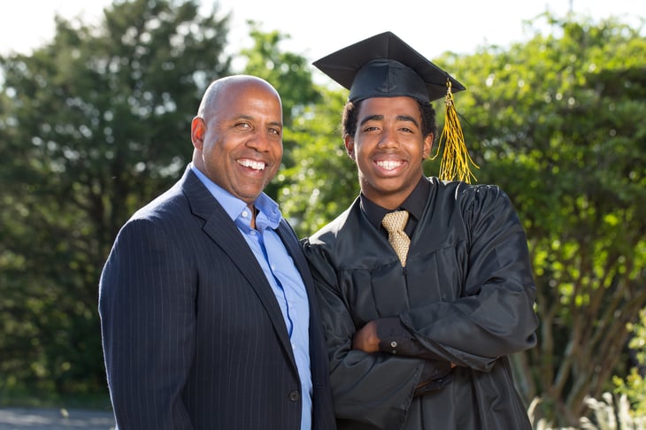 A father and son pose for a photo at the son's graduation