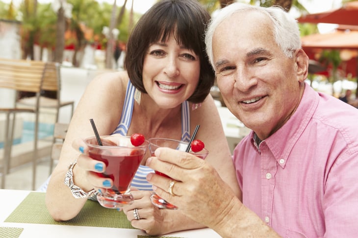 An older couple raises cocktails to toast
