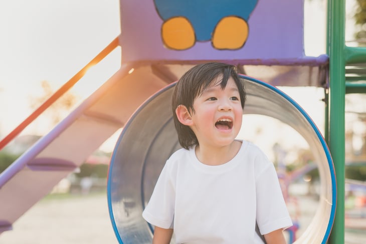 An Asian child plays on a playground