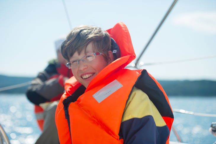 A teenager wears a life jacket while on a boat