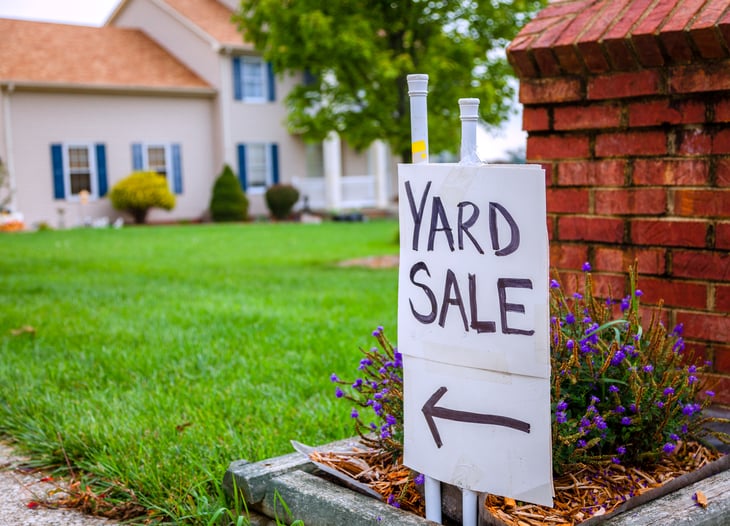 A yard sale sign with an arrow