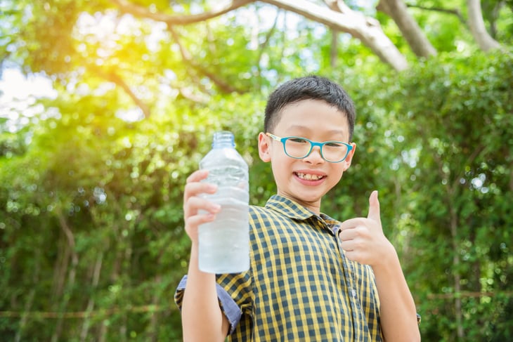 A boy holds a bottle of water