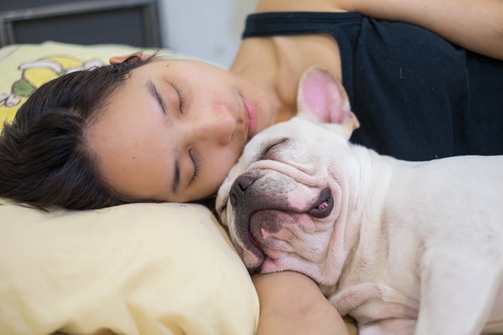 Woman sleeping with her dog
