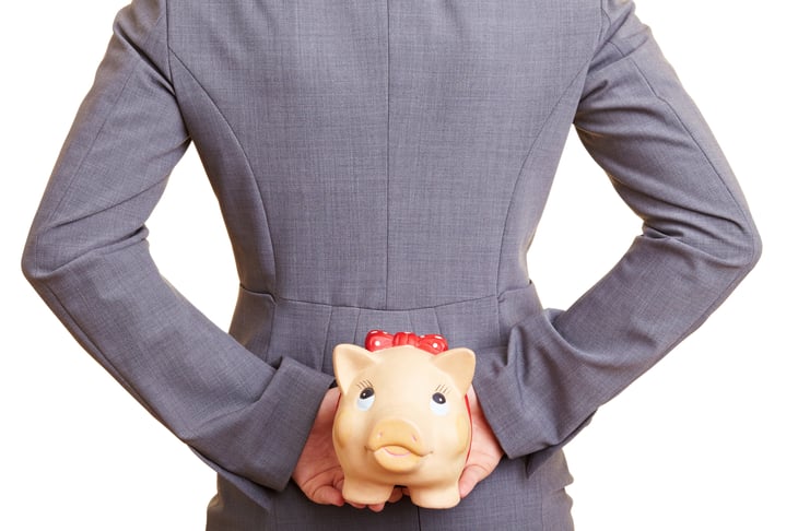 Person hiding piggybank behind back