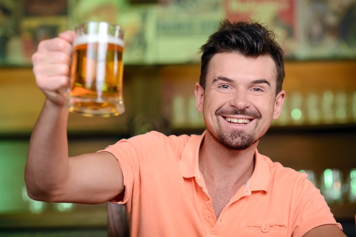 Man raising a glass of beer in cheer