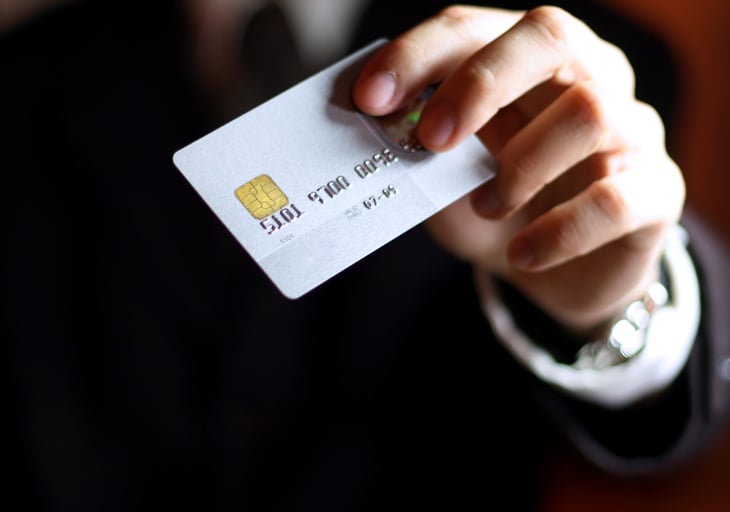 A man holds a credit card with EMV chip technology