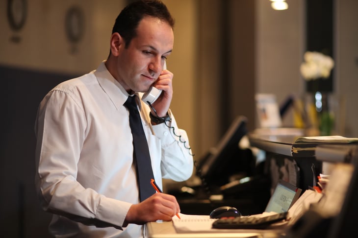 Hotel concierge on phone.