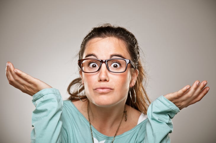 A woman shrugs her shoulders with open palms