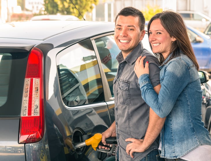 A couple pumps gas at the gas station